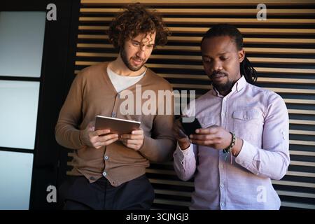 Zwei Geschäftsleute arbeiten mit einem digitalen Tablet-pc zusammen und sprechen über ein Geschäftsprojekt. Stockfoto