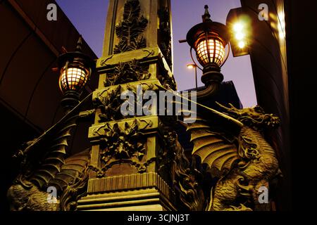 NIHONBASHI, TOKIO, JAPAN: Verzierte Bronzedrachen-Statue und eine leuchtende Laterne auf der historischen Nihonbashi-Brücke in der Abenddämmerung. Ein ikonisches Wahrzeichen in Chuo City Stockfoto