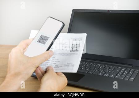 Smartphone scannt QR-Code, um eine Rechnung zu bezahlen Stockfoto