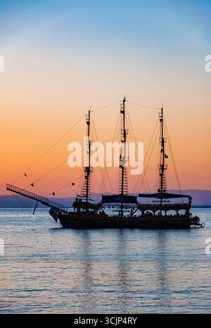 Ein touristisches Piratenschiff, umrahmt von einem Sonnenuntergang. Stockfoto