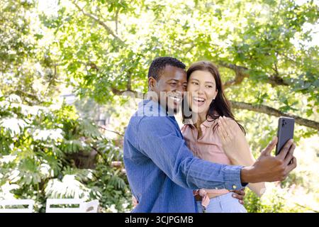 Paare machen Selfie im Freien, lächeln und genießen einen sonnigen Tag in der Natur Stockfoto