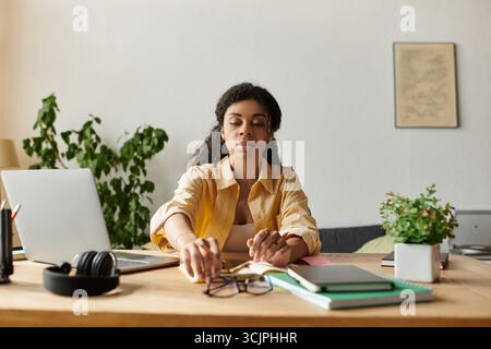 Diese schöne junge Frau konzentriert sich auf ihre Aufgaben an einem modernen Arbeitsplatz, umgeben von Grün. Stockfoto