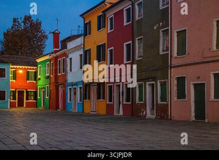 Farbenfrohe Häuser der Insel Burano, die im warmen Herbstsonnenuntergangslicht leuchten, in der Nähe von Venedig, Italien. Stockfoto