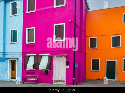 Farbenfrohe Häuser der Insel Burano, die im warmen Herbstsonnenuntergangslicht leuchten, in der Nähe von Venedig, Italien. Stockfoto