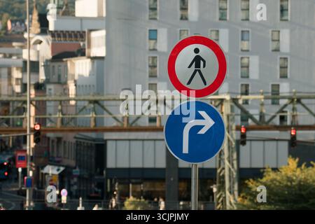 Keine Fußgänger Biegen Sie Rechts Ab Verkehrsschild Stadthintergrund. Urbane Straßenszene mit Verkehrsschildern, die Fußgängern den Zutritt verbieten und die Fahrzeuge dorthin leiten Stockfoto
