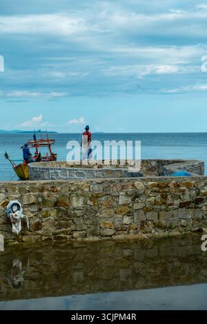 Fischer auf einem Steinpier mit Booten in Koh Rong, Kambodscha. 2018 Stockfoto