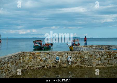 Fischer auf einem Steinpier mit Booten in Koh Rong, Kambodscha. 2018 Stockfoto
