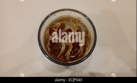 Ein erfrischendes Glas Eiskaffee auf einem Holztisch Stockfoto