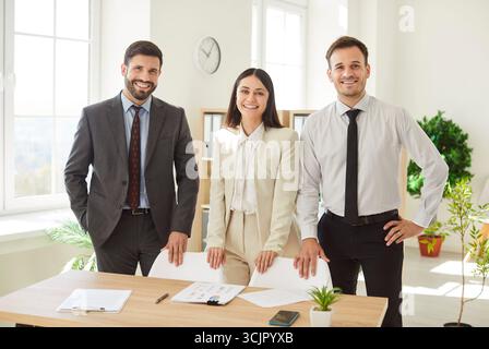 Glückliche Kollegen, die sich in der Vorstandssitzung des Büros treffen, um ein Brainstorming zu treffen und gemeinsam Finanzpapiere zu diskutieren Stockfoto