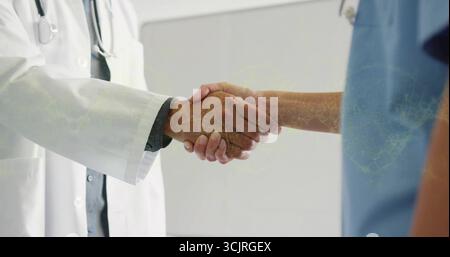 Handschütteln Arzt und Krankenschwester im Krankenhausbüro, mit weißem Labormantel, blauen Peelings und Stethoskop Stockfoto