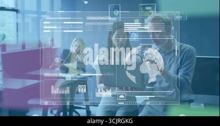 Zwei Kollegen, die Laptopkarten und Datenansichten im Großraumbüro mit Haftnotiztafel anzeigen Stockfoto