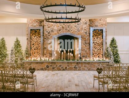 Ein einladender Innenraum für eine Winterhochzeit mit Steinkamin und funkelnden Lichtern. Stockfoto