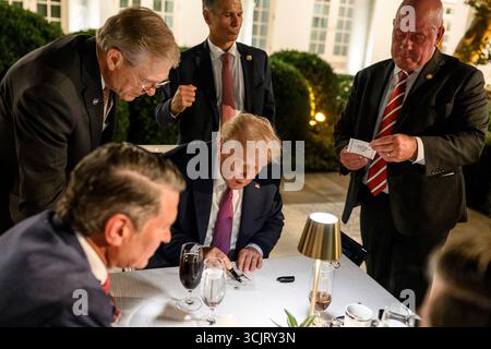 Washington, Usa. September 2025. Mitglieder des Kongresses drängen sich um US-Präsident Donald Trump, Center, während er eine Einladung während der ersten Veranstaltung im Rose Garden, seit sie mit Pflastersteinen im Weißen Haus bedeckt, am 5. September 2025 in Washington, D.C. autographiert. Credit: Daniel Torok/White House Photo/Alamy Live News Stockfoto