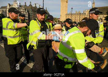 Die Polizei führt einen verhafteten Demonstranten aus dem Parliament Square im Zentrum Londons während der Demonstration „Lift the Ban“ zur Unterstützung der verbotenen Grou Stockfoto