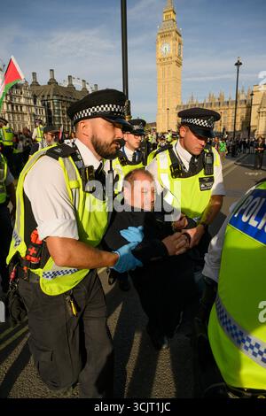 Die Polizei führt einen verhafteten Demonstranten aus dem Parliament Square im Zentrum Londons während der Demonstration „Lift the Ban“ zur Unterstützung der verbotenen Grou Stockfoto