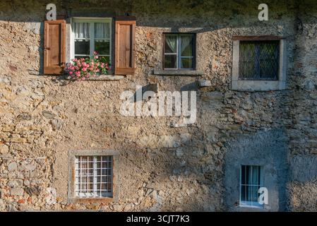 Fenster eines alten Hauses mit Blumen auf dem Balkon Stockfoto