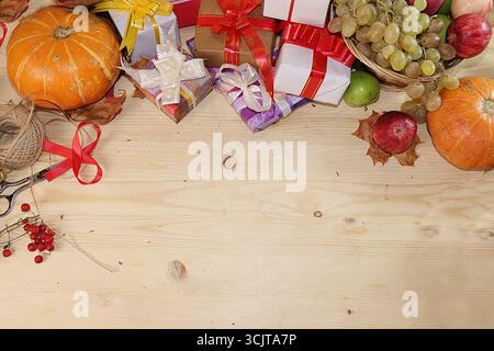 Geschenkverpackung zum Tag blagodoreniya, Herbst Hintergrund mit saisonalen Beeren Natur Herbst, Kürbisse, Äpfel, Trauben und Geschenke auf hölzernem Hintergrund, t Stockfoto