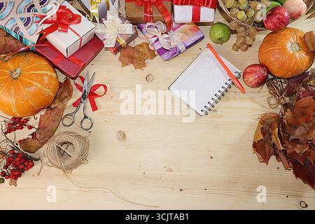 Geschenkverpackung zum Tag blagodoreniya, Herbst Hintergrund mit saisonalen Beeren Natur Herbst, Kürbisse, Äpfel, Trauben und Geschenke auf hölzernem Hintergrund, t Stockfoto