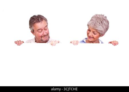 Zwei Senioren, die auf ein weißes Poster schauen, Vorderansicht Stockfoto