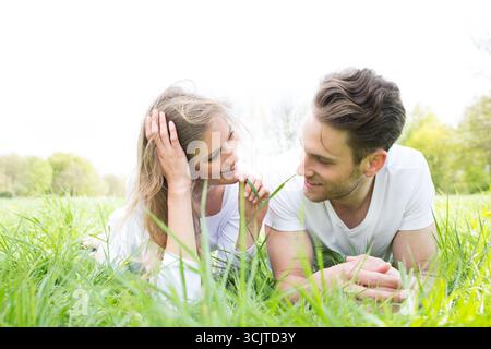 Verliebtes Paar, das auf einer Wiese flirtet Stockfoto