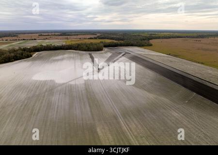 Luftaufnahme des Bewässerungssystems zur Bewässerung des Bauernhofes während der Trockenzeit. Industriesprinkler sprühen Wasser auf Ackerland für Erntewachstum während Stockfoto