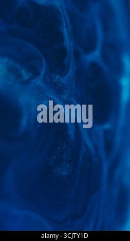 Tintenmaserung. Glänzende Flüssigkeit. Unschärfe blaue Farbe Wasserstruktur Staub funkelnder Mischfluss verbreitet sich auf abstraktem kreativem Acrylkunsthintergrund. Stockfoto