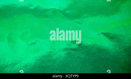 Leuchtend grüne Folienpapierstruktur, abstrakter glänzender Hintergrund Stockfoto