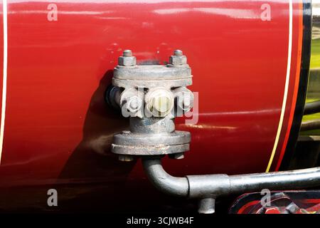 Nahaufnahme eines rot-schwarzen Traktors oder eines dampfbetriebenen Traktors Stockfoto