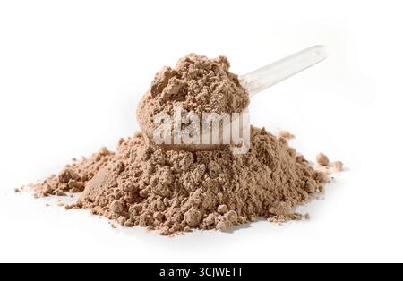Haufen und Löffel braunes Proteinpulver mit Schokoladengeschmack, isoliert auf weißem Hintergrund Stockfoto