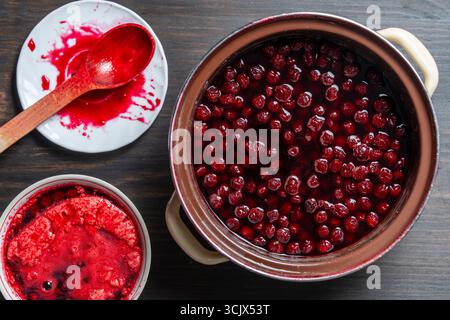 Köstliche Kirschmarmelade in einem Topf auf einem Holztisch, Nahaufnahme, Blick von oben. Sommerzubereitung und Konservierung von Beeren für den Winter, Hausmannskost Stockfoto