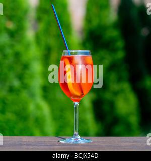 Aperol spritzt Cocktail in Weinglas auf einem Naturhintergrund. Klassischer italienischer aperol-Spritz-Cocktail mit Orangenscheibe. Nahaufnahme. Sommer Stockfoto