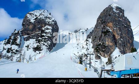 Olympische Abfahrt Olimpia 1 in Cortina d’Ampezzo in den Dolomiten, Italien. Der steilste Teil zwischen großen Felsen. Skilift und nicht erkennbare Skifahrer. Stockfoto