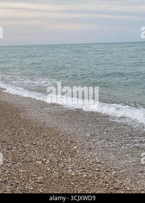 Sanfte Wellen, die sanft auf den Kiesstrand von Pineto in den Abruzzen, Italien, plätschern und eine ruhige und ruhige Atmosphäre schaffen Stockfoto