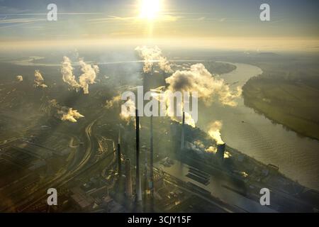 Luftansicht, Thyssen Krupp Steel Europe AG am Rhein, Schwelgern Werkshafen, Hintergrundbeleuchtung und strahlende Sonne am blauen Himmel, rauchende Rauchschmelze Stockfoto