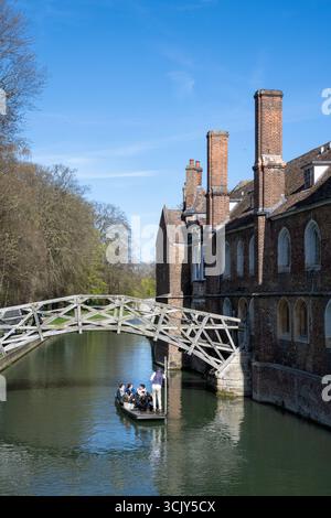 Touristen peitschen unter der Mathematical Bridge am Queens' College, Cambridge, und genießen einen hellblauen Frühlingstag auf dem Fluss Cam Stockfoto