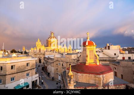 Skyline von Rabat mit der St. Paul Kirche Kuppel auf der linken Seite bei Sonnenuntergang, Rabat Mdina, Malta Stockfoto