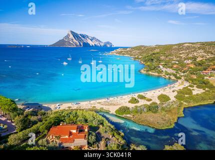 Blick aus der Vogelperspektive auf den Strand Cala Girgolu in Sardinien, Italien mit Insel Tavolara, türkisfarbenem Wasser, Segelbooten, Natur und mediterraner Landschaft Stockfoto