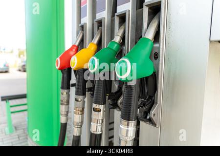 Nahaufnahme von vier Kraftstoffdosierdüsen an einer Gaspumpe, bereit zum Betanken. Eine detaillierte Ansicht der modernen Tankstellenausstattung. Stockfoto