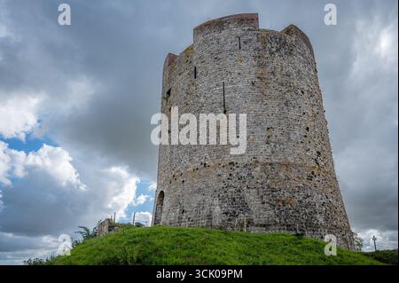 Blick auf den noch vorhandenen runden Donjon von Guise Castle in Aisne, Frankreich, dramatisch vor dunklen, stürmischen Wolken. Stockfoto