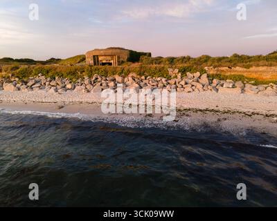 Drohnenfoto eines Blockhauses der Atlantic Wall in Gavres, Frankreich, aus dem Meer in Augenhöhe aufgenommen und zeigt den Bunker aus dem Zweiten Weltkrieg in seiner Küstenlage. Stockfoto