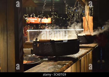 Sauerkraut und Würstchen kochen am Feuer auf dem Weihnachtsmarkt in Tallinn, Estland, Dezember 2024 Stockfoto