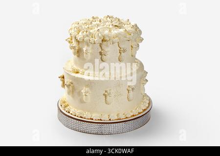 Köstliche zweistufige weiße Hochzeitstorte, dekoriert mit Gold und Perlen Stockfoto