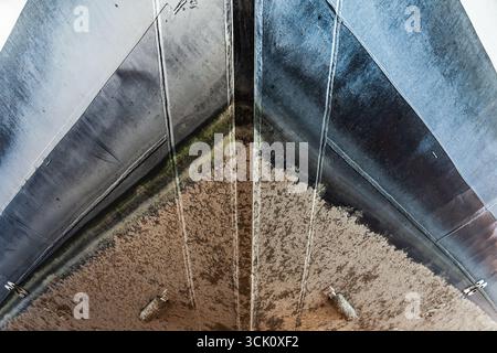 Vorderer Bug einer Luxusyacht mit sichtbarer Wasserlinie und weißem Rumpf von unten, Nahaufnahme Stockfoto