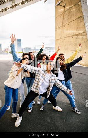 Glückliche Freunde, die Arme heben und Spaß haben Stockfoto