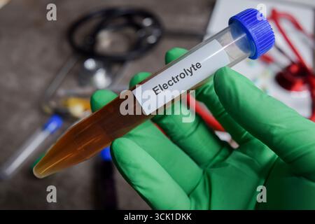 Elektrolytschutzmittel in grünen Handschuhen. Medizinisches Konzept Stockfoto