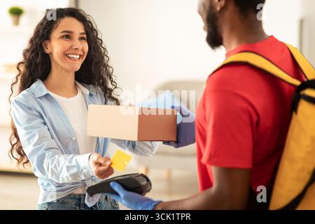 Porträt eines schwarzen Mannes, der die Kasse für die Zahlung hält Stockfoto