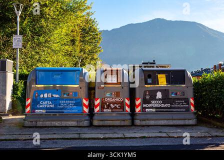 Feltre, Veneto, Italien - 2. November 2024: Recyclingbehälter für Papier, organische Abfälle und nicht recycelbare Materialien befinden sich entlang einer Straße Stockfoto
