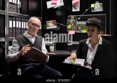 Privates Ermittlungsteam untersucht Überwachungsfotos und geheime Aufzeichnungen und verknüpft Hinweise in den Falldateien, um Beweise zu sammeln und einen Kriminellen mit einer Expertenauswertung zu identifizieren. Stockfoto