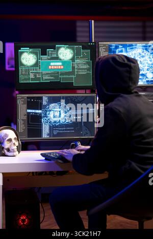 Hacker sieht auf PC-Monitoren eine Nachricht, die Zugriff verweigert hat, während er versucht, die Unternehmenssysteme zu verletzen. Nicht autorisierte Programmierer werden abgelehnt, wenn sie versuchen, Unternehmensnetzwerke zu infiltrieren, ohne Passwort zu knacken Stockfoto