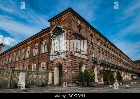 Eine Weitwinkelaufnahme der Biblioteca reale auf der Piazza Castello, Turin. Das Foto zeigt die kunstvolle Barockarchitektur vor einem markanten Himmel. Stockfoto
